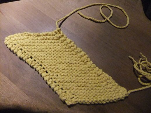 Tout en laissant un long fil au début, monter le nombre de mailles nécessaire pour faire environ 15 cm. Tricoter les rangs pairs à l'endroit, les rangs impairs à l'endroit aussi, en faisant une diminution au début du rang, et une augmentation en fin de rang. Continuer jusqu'à ce que la hauteur fasse environ 25 cm, laisser un long fil après avoir rabattu les mailles.