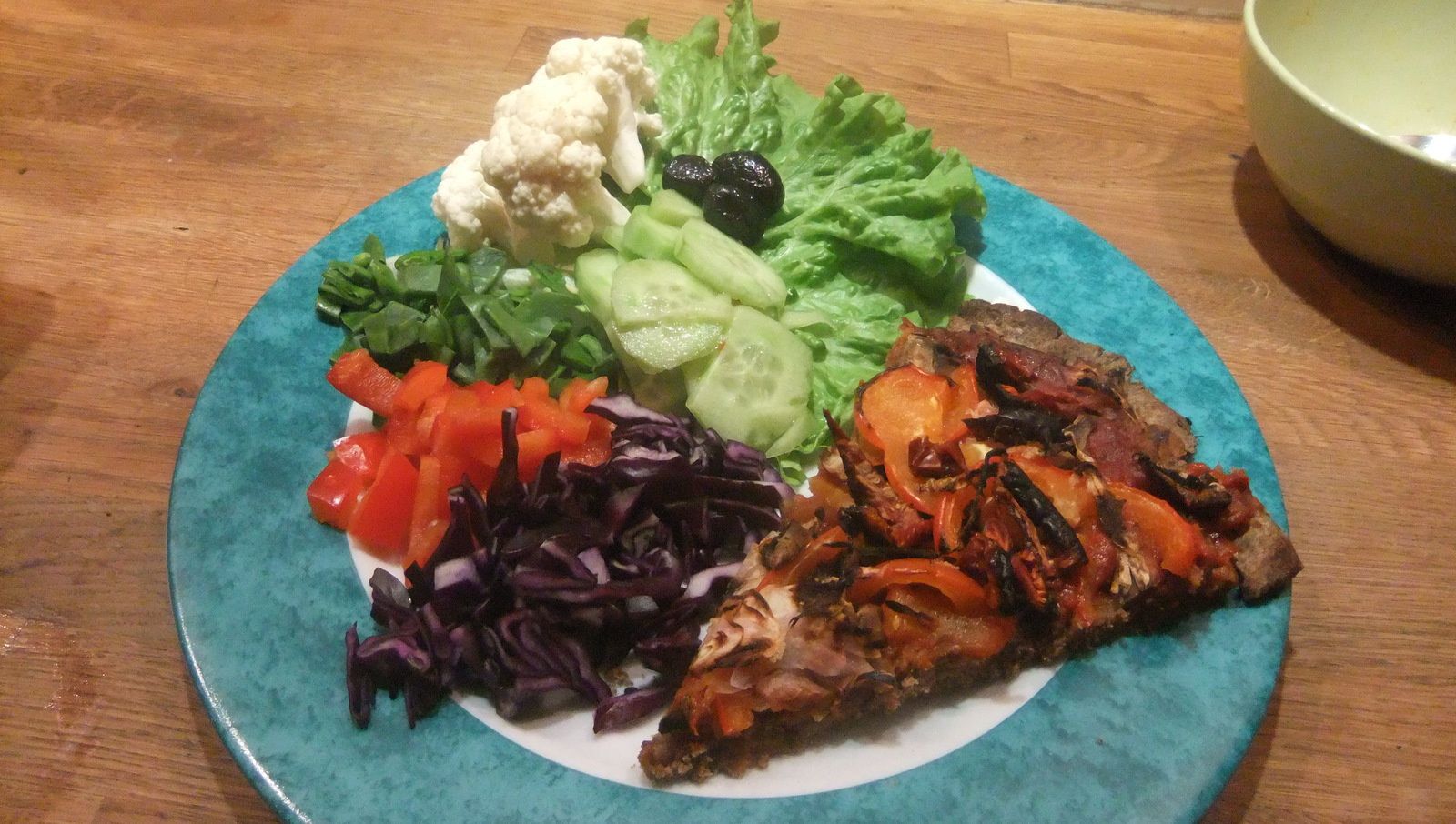 Pizza sans gluten, salade, olives noires, chou-fleur, pois gourmands, poivrons rouges, chou rouge
