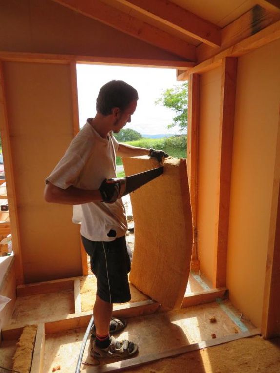 On isole le plancher et les murs en bourrant les caissons de laine de bois (en n'oubliant pas les petits coins, merci les petites mains !)